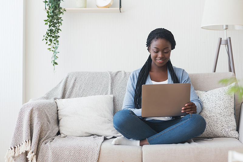 Frau mit Laptop auf dem Sofa findet über Google den passenden Onlineshop.