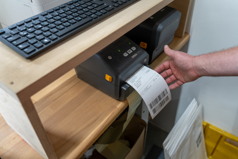Mitarbeiter Druckt Etikett zum Versand