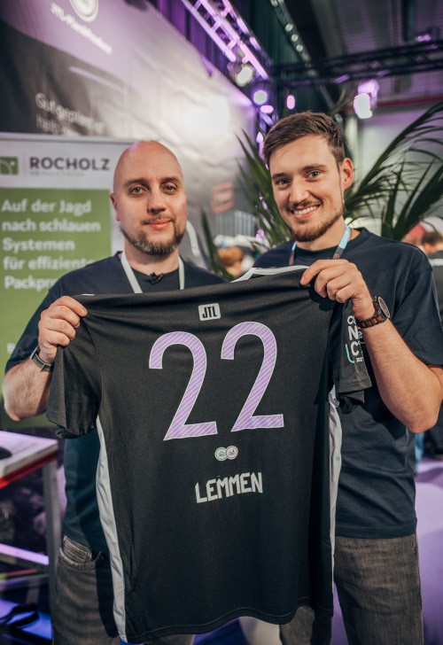 JTL-Connect 2022: Besucher der Demo-Produktion JTL-Plan&Produce zeigen ihr fertiges Trikot