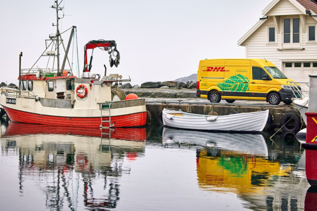 DHL Auto am Ufer mit Fischerboot