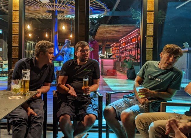 Männer sitzen nebeneinander und trinken Bier am Abend