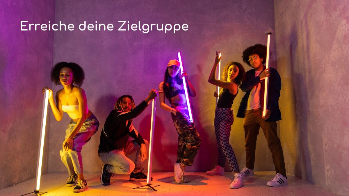 Junge Menschen posieren mit bunten Leuchtstäben