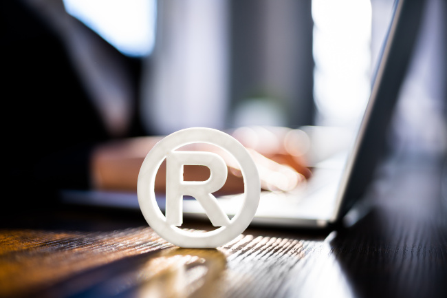 Registered Trademark Symbol auf Holztisch mit Laptop