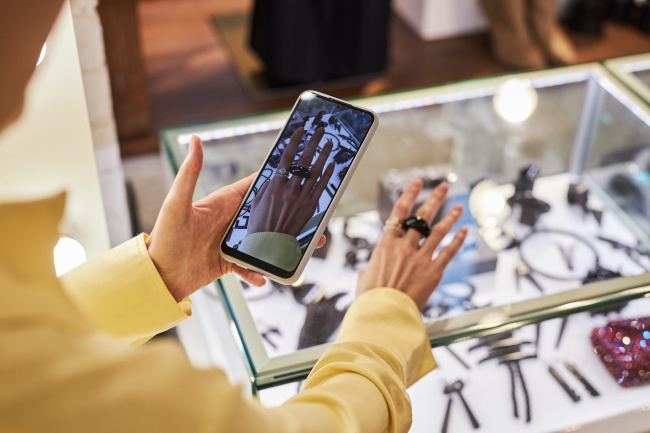 Person mit Handy filmt Ring an der Hand
