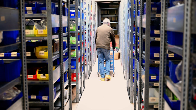 Mitarbeiter zwischen Regalen im Lager bei Kalitec