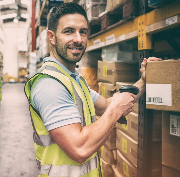 Mann scannt im Lager ein Paket mit einem mobilen Scanner