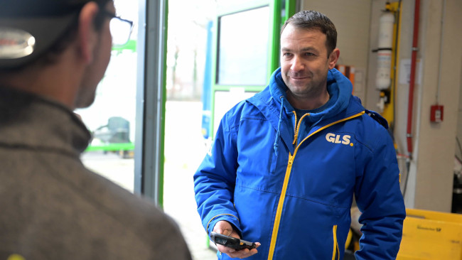 Mitarbeiter von GLS spricht mit Kunden
