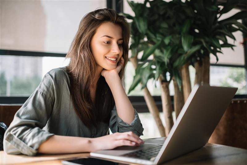 Junge Frau am Schreibtisch vor Laptop