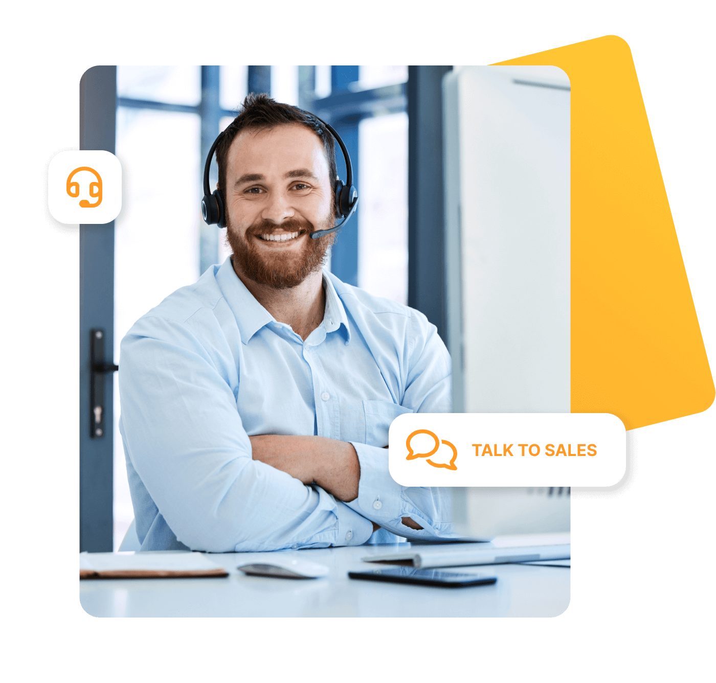 A friendly, smiling man wearing a headset sits at a desk in a bright office. He is wearing a light blue shirt and has his arms loosely crossed. On the table are a tablet, a computer mouse and a notepad. Symbols appear on the screen showing a headset and the words 