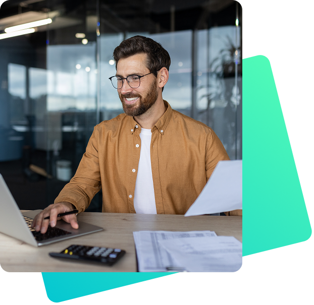 Mann arbeitet im Büro mit Laptop und prüft Dokumente zur Logistik- oder Auftragsabwicklung