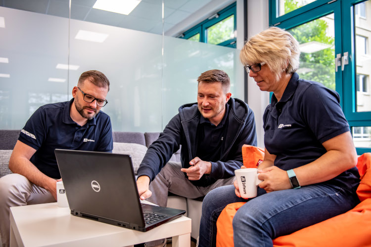 JTL-Mitarbeiter in der Teambesprechung mit Kaffee und Laptop