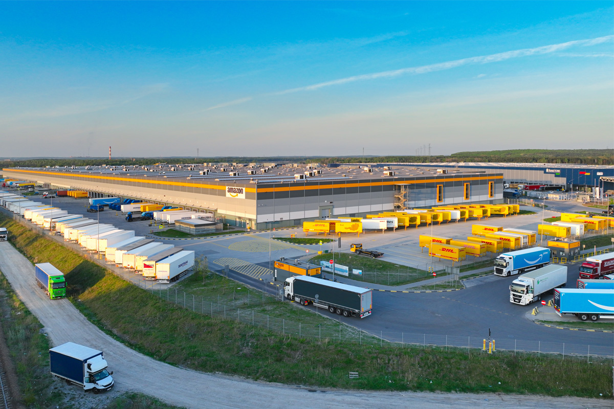Ein großes Fulfillment Center in Polen vor dem viele LKWs und Container stehen.