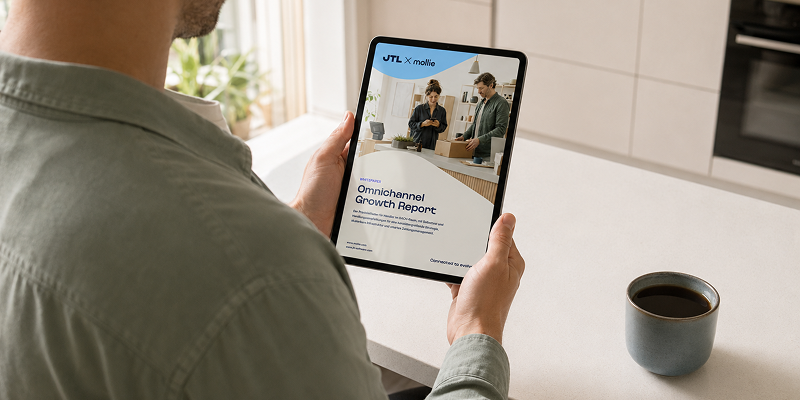 Ein Mann liest den JTL x Mollie Omnichannel Growth Report auf einem Tablet, im Hintergrund eine Tasse Kaffee auf der Küchenarbeitsplatte.
